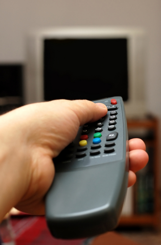hand_using_a_remote_control_tv_blurred_in_the_background_